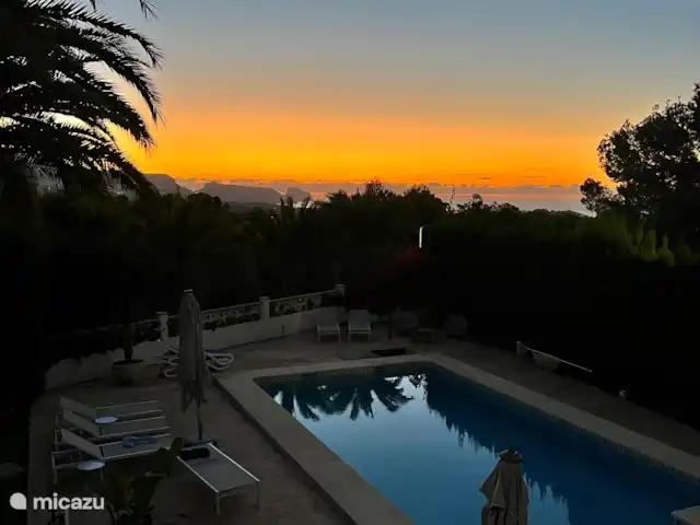 Casa Prima huren in Spanje, Costa Blanca, Alfáz del Pi - appartement Elke ochtend word je getrakteerd op een spectaculaire zonsopkomst – de perfecte start van een ontspannen dag. Of je nu geniet van het zwembad of tot rust komt in een van de vele sfeervolle zitjes onder de palmbomen rondom het huis.