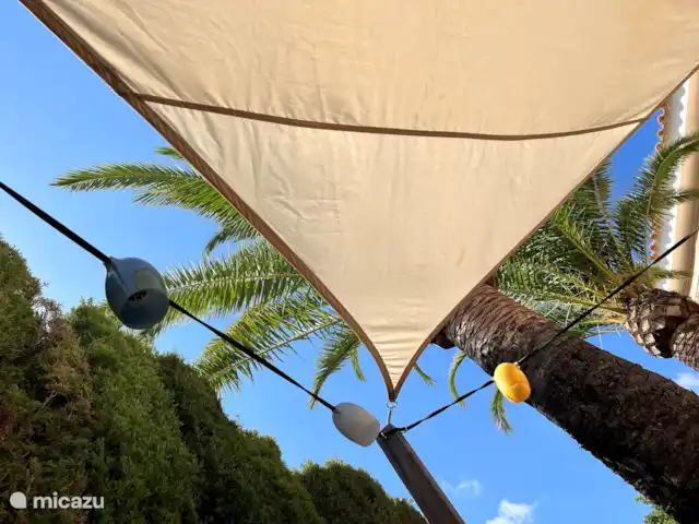Casa Prima huren in Spanje, Costa Blanca, Alfáz del Pi - appartement Een van de meerdere schaduwrijke zitjes in de tuin, voorzien van een praktisch schaduwdoek. Perfect om te ontspannen en te genieten, zelfs tijdens de warmste uren van de dag.