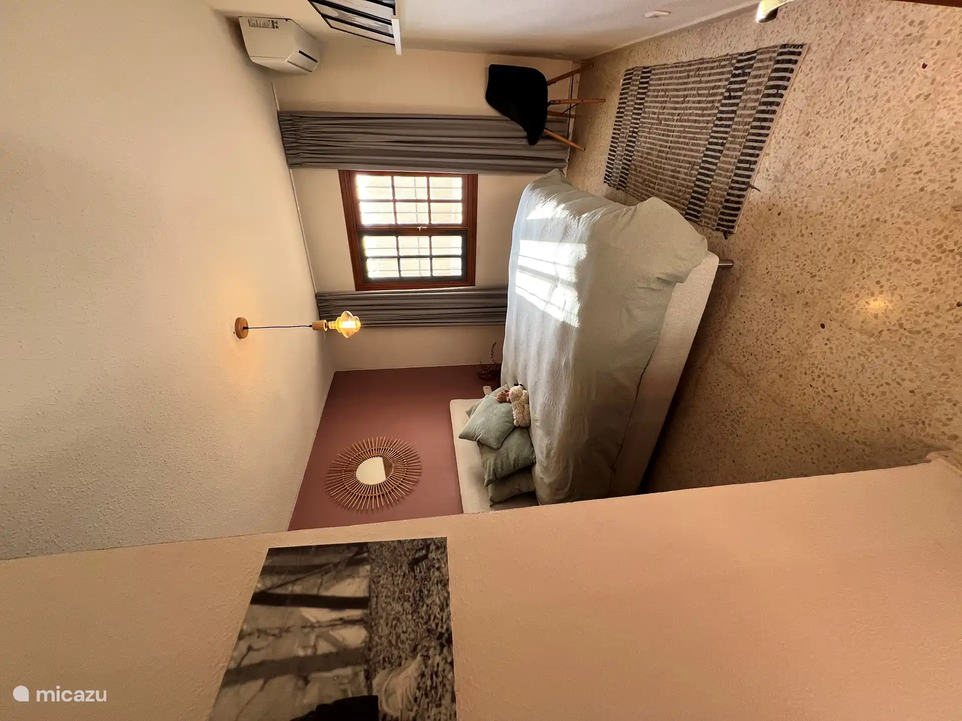 El dormitorio, con una cómoda cama de 1,60m, visto desde un ángulo diferente. Las cortinas opacas grises garantizan una buena noche de sueño.