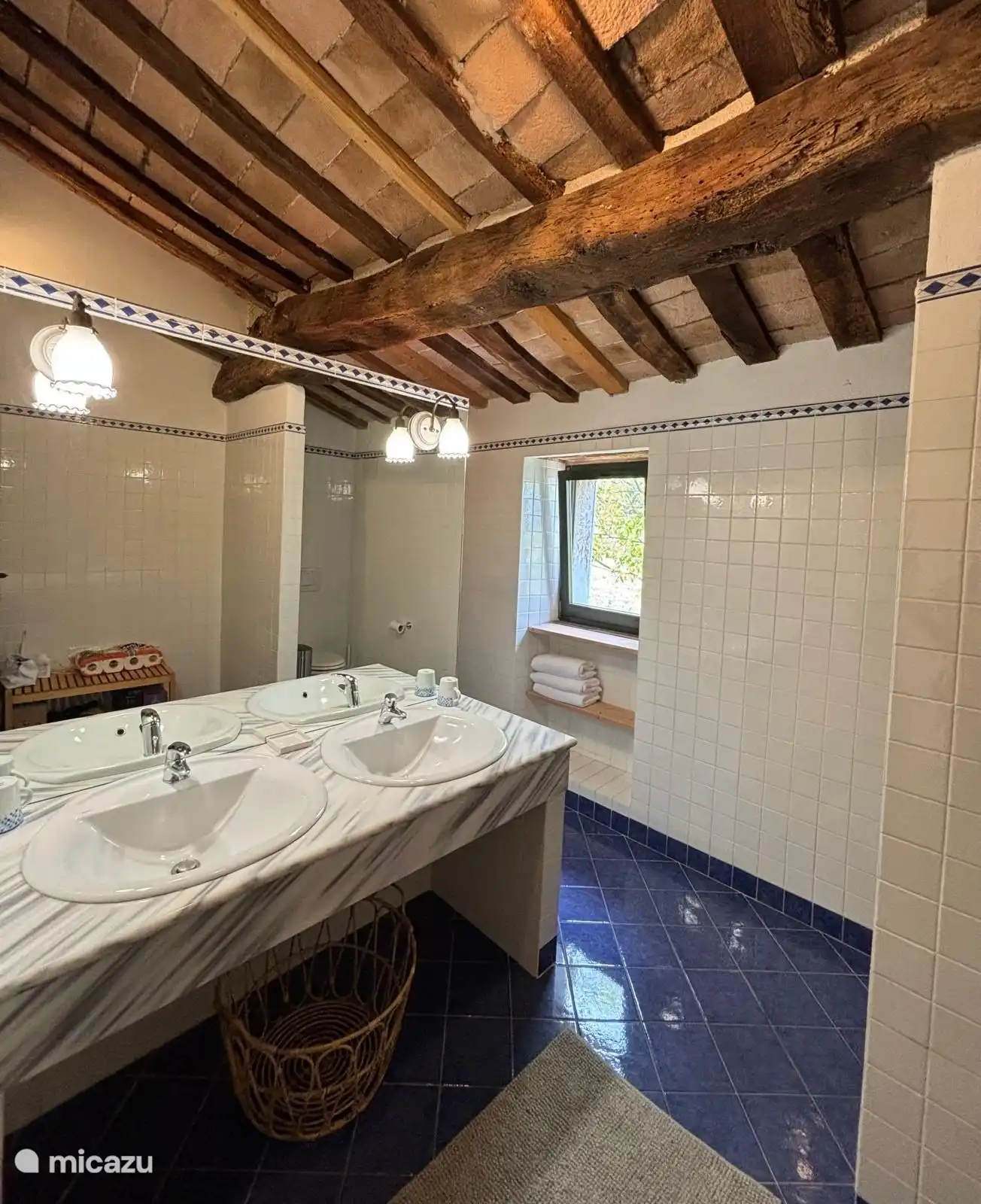 Badezimmer mit geräumiger Dusche, zwei Waschbecken und einer Toilette.