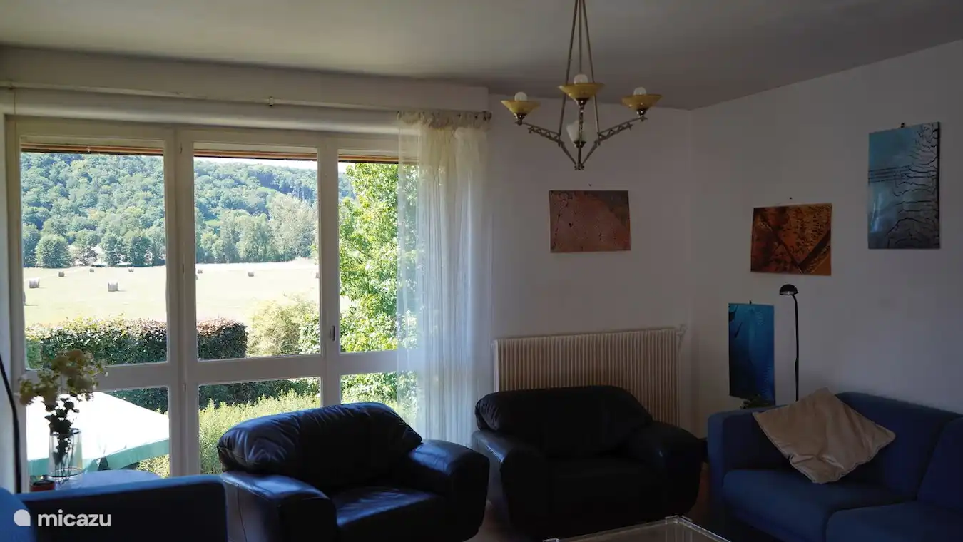 Wohnzimmer mit Blick auf Wald und Wiesen.