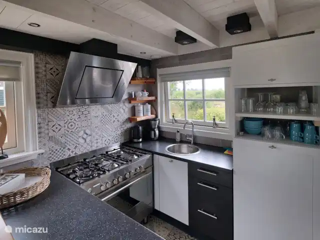 `t Bullekroffie Bonte Koe 1 huren in Nederland, Noord-Holland, Oudesluis - vakantiehuis Compacte keuken voorzien van vaatwasser, groot fornuis met oven, koelkast, filterkoffiezetapparaat, waterkoker en voldoende servies. Een leuke bar met krukken maakt het compleet.In de schuur een extra koel/vrieskast en magnetron.