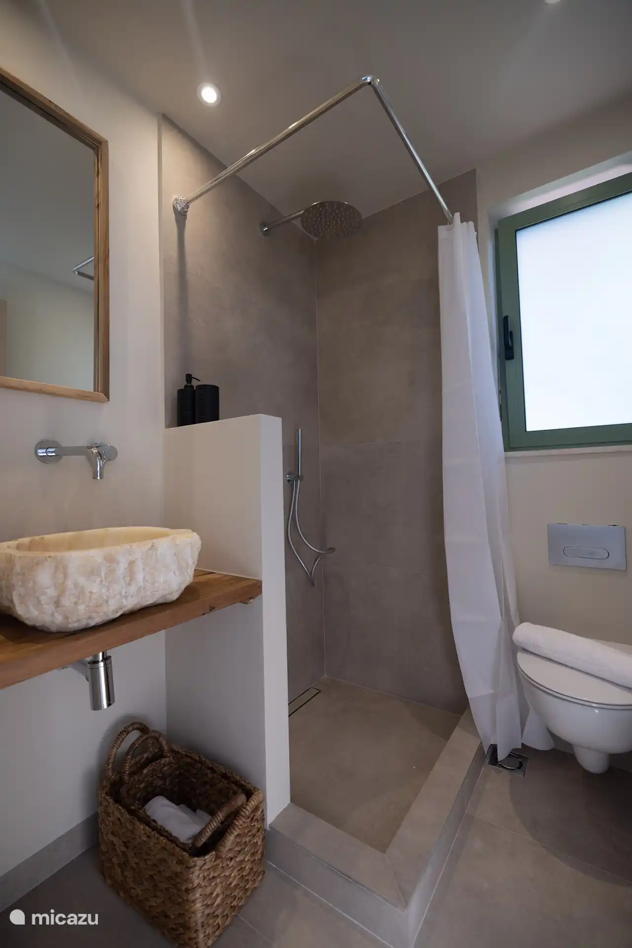 Badkamer met regendouche en stenen wastafel 