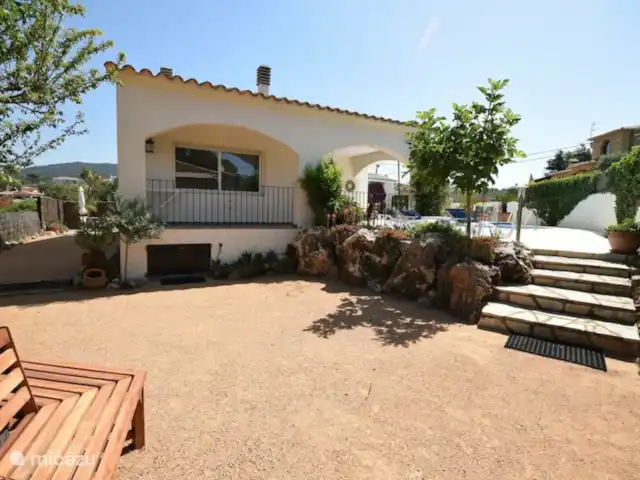 Villa EL SOL en España, Costa Brava, Calonge - villa Lado de la casa con un banco alrededor de la palmera.