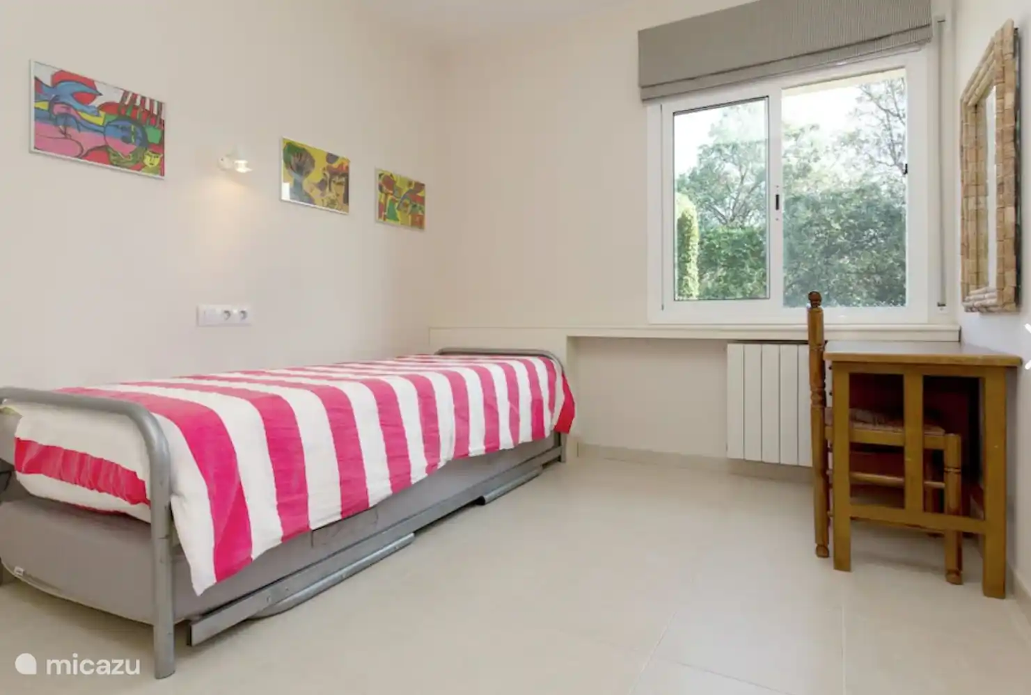 Schlafzimmer mit zwei Einzelbetten, davon 1 Ausziehbett und einem kleinen Schreibtisch/Kommode.