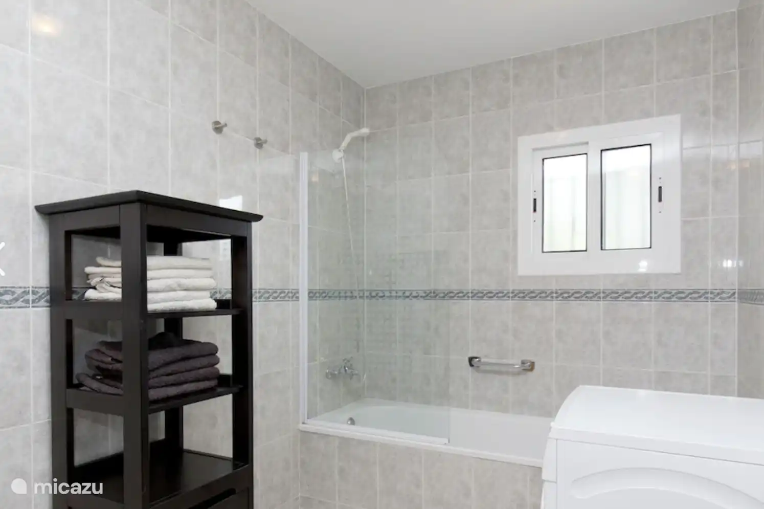 Großes Badezimmer mit Dusche/Badewanne, Waschbecken, WC und Waschmaschine.