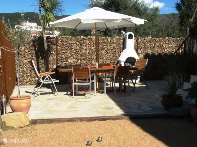 Villa EL SOL en España, Costa Brava, Calonge - villa Terraza con mesa y sillas de comedor en la pista de petanca con barbacoa de piedra.