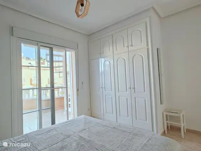 Casa Miramar en España, Costa Blanca, Ciudad Quesada - casa vacacional En la “Habitación Verde” de Casa Miramar, una cómoda cama de matrimonio cobra protagonismo, rodeada de grandes armarios empotrados. Un balcón privado ofrece un refugio tranquilo, donde los huéspedes pueden disfrutar de los serenos sonidos del entorno y comenzar el día con una brisa refrescante.
