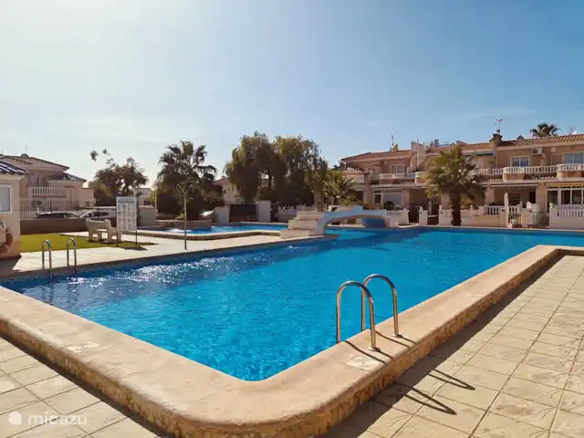 Casa Miramar en España, Costa Blanca, Ciudad Quesada - casa vacacional La zona poco profunda de 10 por 10 metros es un animado parque infantil para los niños, mientras que la zona profunda de 10 por 20 metros ofrece un oasis de paz para los bañistas. Rodeada de palmeras y tumbonas, esta piscina es el corazón del relax y la convivencia.