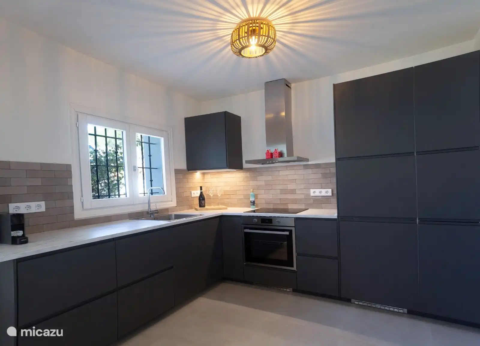 Voici notre nouvelle cuisine, équipée d'une plaque à induction, d'un grand réfrigérateur, d'un four/grill, d'un lave-vaisselle, d'une machine à café Nespresso, d'un grille-pain.