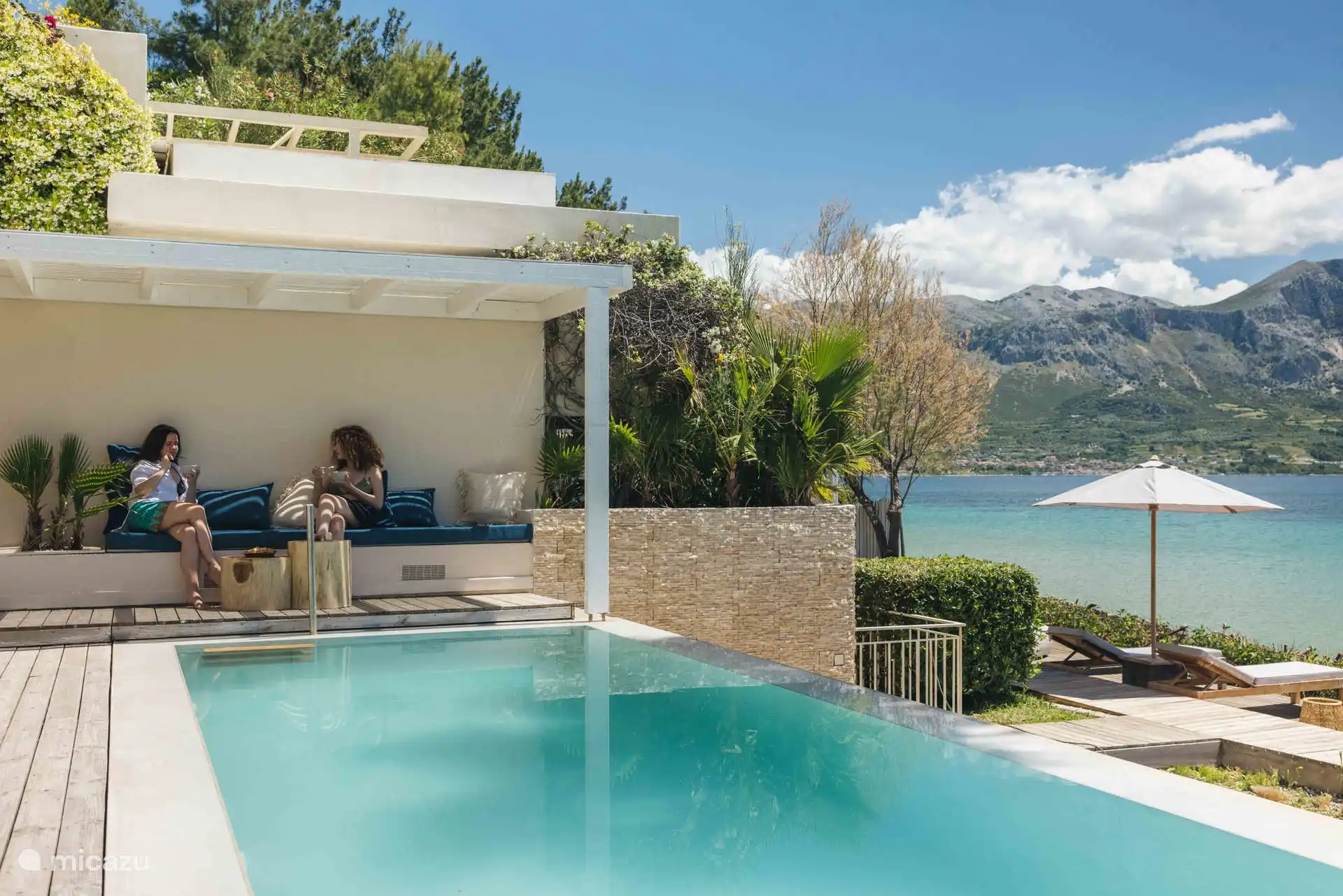 Coin salon extérieur au bord de la piscine