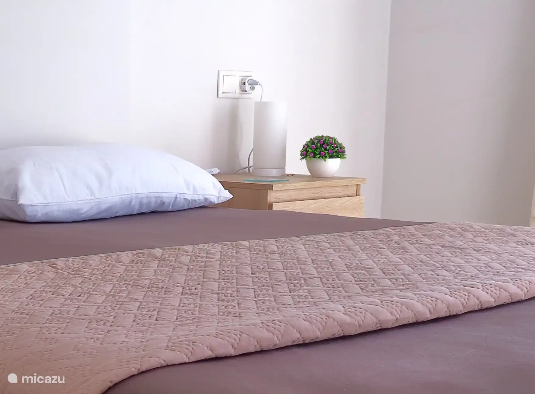 La chambre avec le lit double avec des couleurs principales marron foncé et chêne blanc