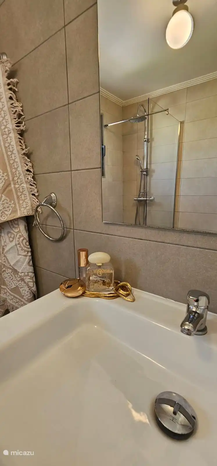 Salle de bain fraîche avec douche, lavabo et WC.