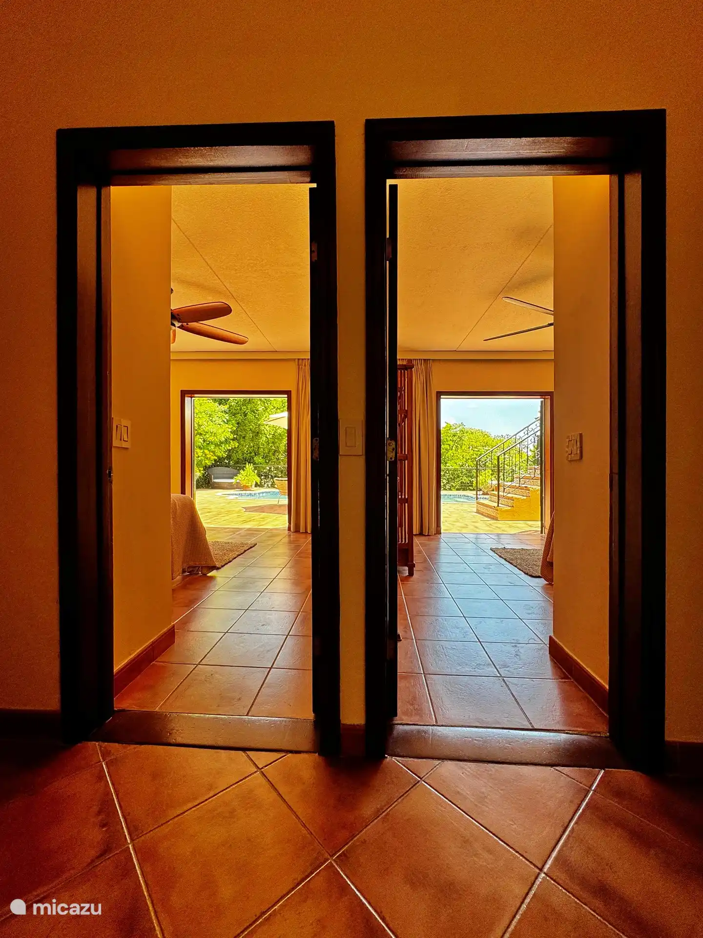 Blick vom Flur durch zwei der Schlafzimmer auf die Terrasse und den Pool