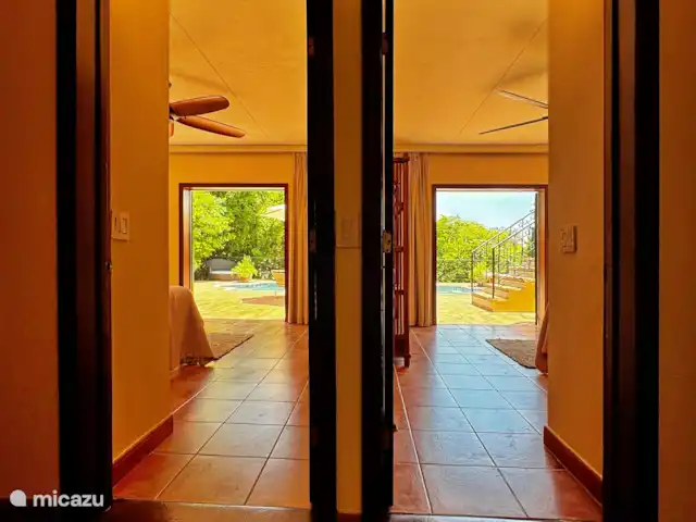 Location de Vacances Curaçao, Curaçao-Centre, Mahaai/Damacor, villa - Villa Casablanca Premier Étage Vue sur la terrasse et la piscine depuis le couloir traversant deux des chambres