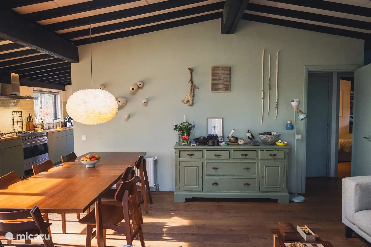 Großer Esstisch und geräumige Küche mit Herd, Pfannen, Geschirr und Gläsern für burgundische Küche und Genuss