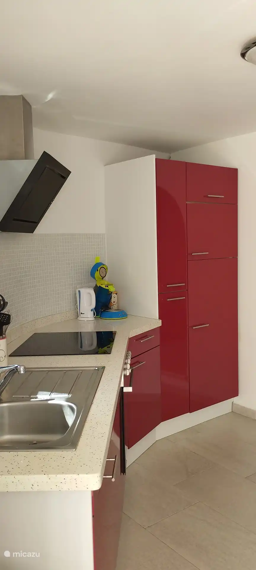 Het zijaanzicht van de keuken. De keuken is van alle gemakken voorzien en heeft een oven, elektrische kookplaat, vaatwasser en voldoende servies en keukenbenodigdheden. Mocht u een keer geen behoefte hebben om uit eten te gaan, in deze keuken maakt u zelf een prima maaltijd! 