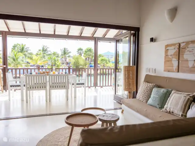 villa huren in Bonaire, Bonaire, Kralendijk – Blou Bonaire Waterlands Village De woonkamer is ingericht met een 2 en 3 persoonsbank. Tv kijken kan je naar een groot aantal tv zenders.