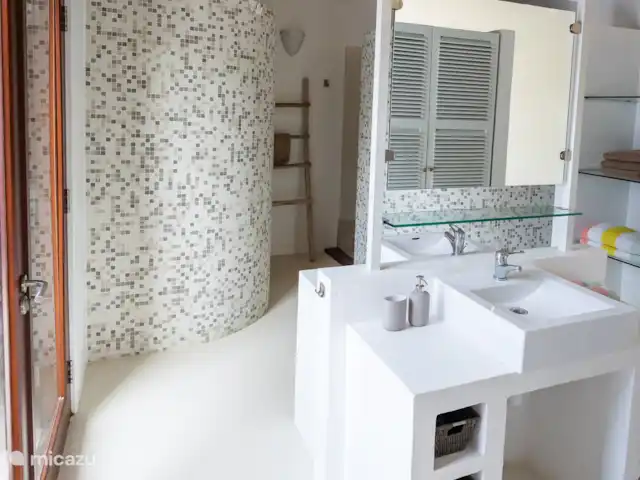 villa huren in Bonaire, Bonaire, Kralendijk – Blou Bonaire Waterlands Village De ensuite badkamer van de Master bedroom beschikt over 2 wastafels en een douche. Tevens een ruimte kledingkast waarin zich ook een kluisje bevindt.