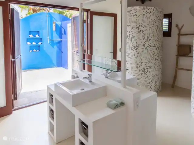 villa huren in Bonaire, Bonaire, Kralendijk – Blou Bonaire Waterlands Village De ensuite badkamer van de Master bedroom beschikt over 2 wastafels en een douche. Tevens een ruimte kledingkast waarin zich ook een kluisje bevindt.