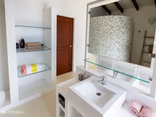 villa huren in Bonaire, Bonaire, Kralendijk – Blou Bonaire Waterlands Village De ensuite badkamer van de Master bedroom beschikt over 2 wastafels en een douche. Tevens een ruimte kledingkast waarin zich ook een kluisje bevindt.