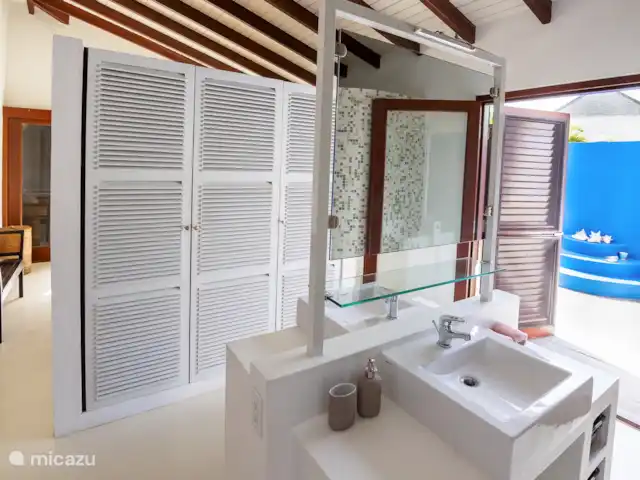 villa huren in Bonaire, Bonaire, Kralendijk – Blou Bonaire Waterlands Village De ensuite badkamer van de Master bedroom beschikt over 2 wastafels en een douche en toilet. Tevens een ruimte kledingkast waarin zich ook een kluisje bevindt.