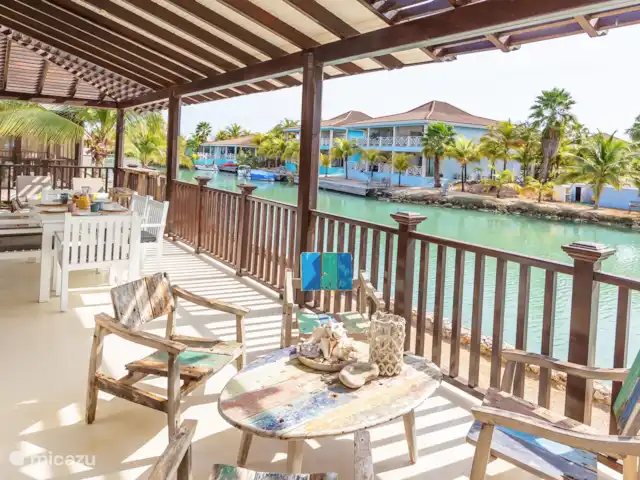 villa huren in Bonaire, Bonaire, Kralendijk – Blou Bonaire Waterlands Village De veranda biedt een prachtig uitzicht over het water. Hier kan je aan een ruime eettafel lekker eten. Ook staan er twee ligbedden en is er een zithoek aanwezig. Een heerlijke plaats om te vertoeven wanneer je je op het resort bevindt.