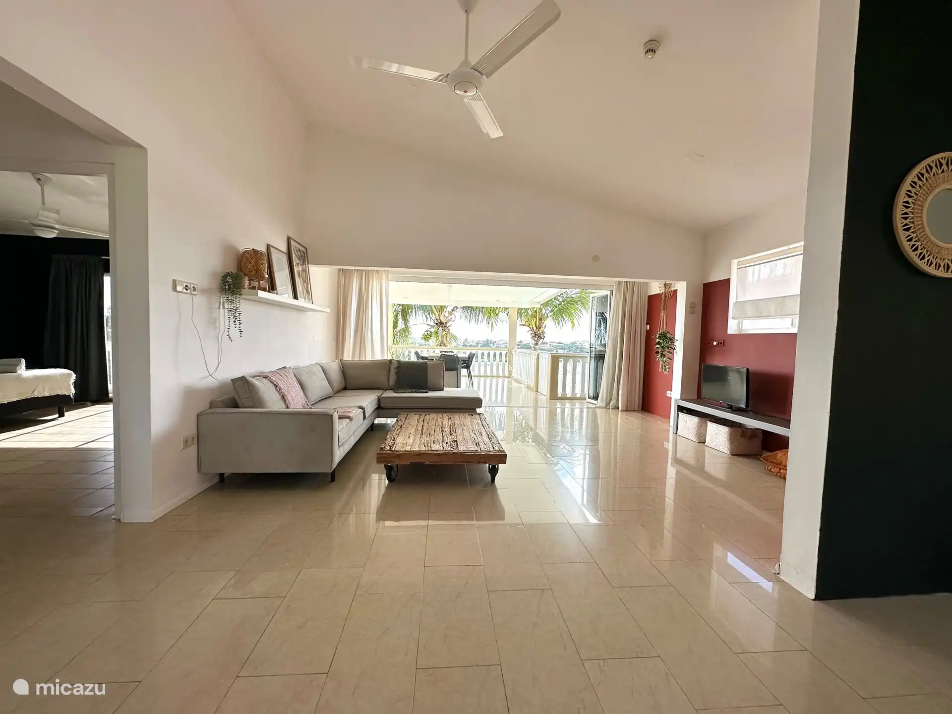 Das Wohnzimmer mit Sitzecke und die Terrasse mit Harmonikatür. 