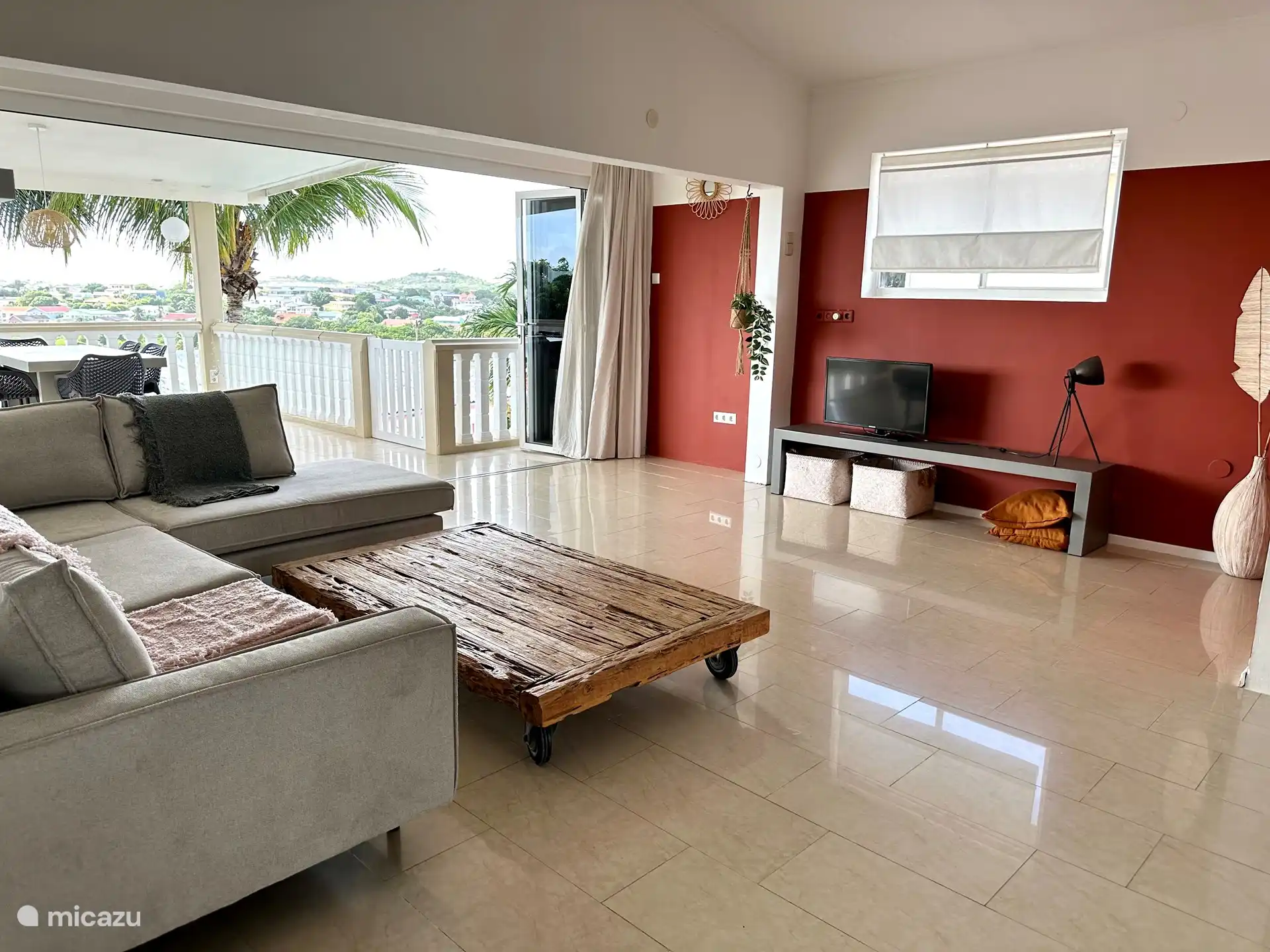 Das Wohnzimmer mit Sitzecke und die Terrasse mit Harmonikatür. 