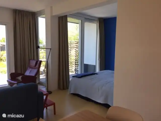 Doppelbett im Alkoven, der tagsüber als Loungebereich genutzt werden kann. Mit Blick auf den Garten.