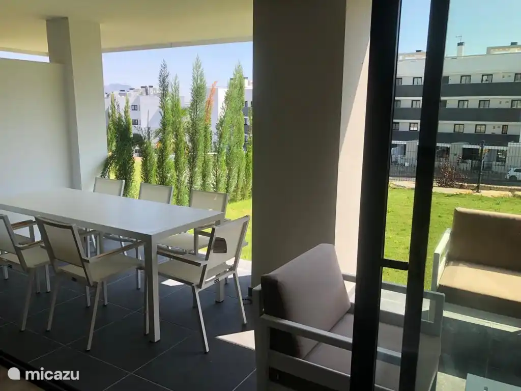 Glasschiebetüren über die gesamte Breite ermöglichen den Zugang zum Garten. 