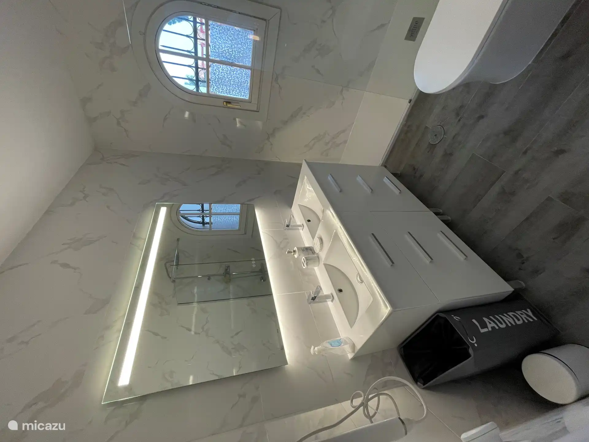 Bathroom furniture with double sink and an electric towel heater.