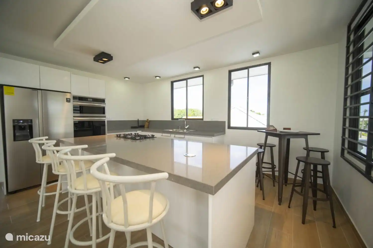 Luxury kitchen with an American fridge, built-in oven and microwave. There is also a separate high bar table and bar stools where you can enjoy a drink