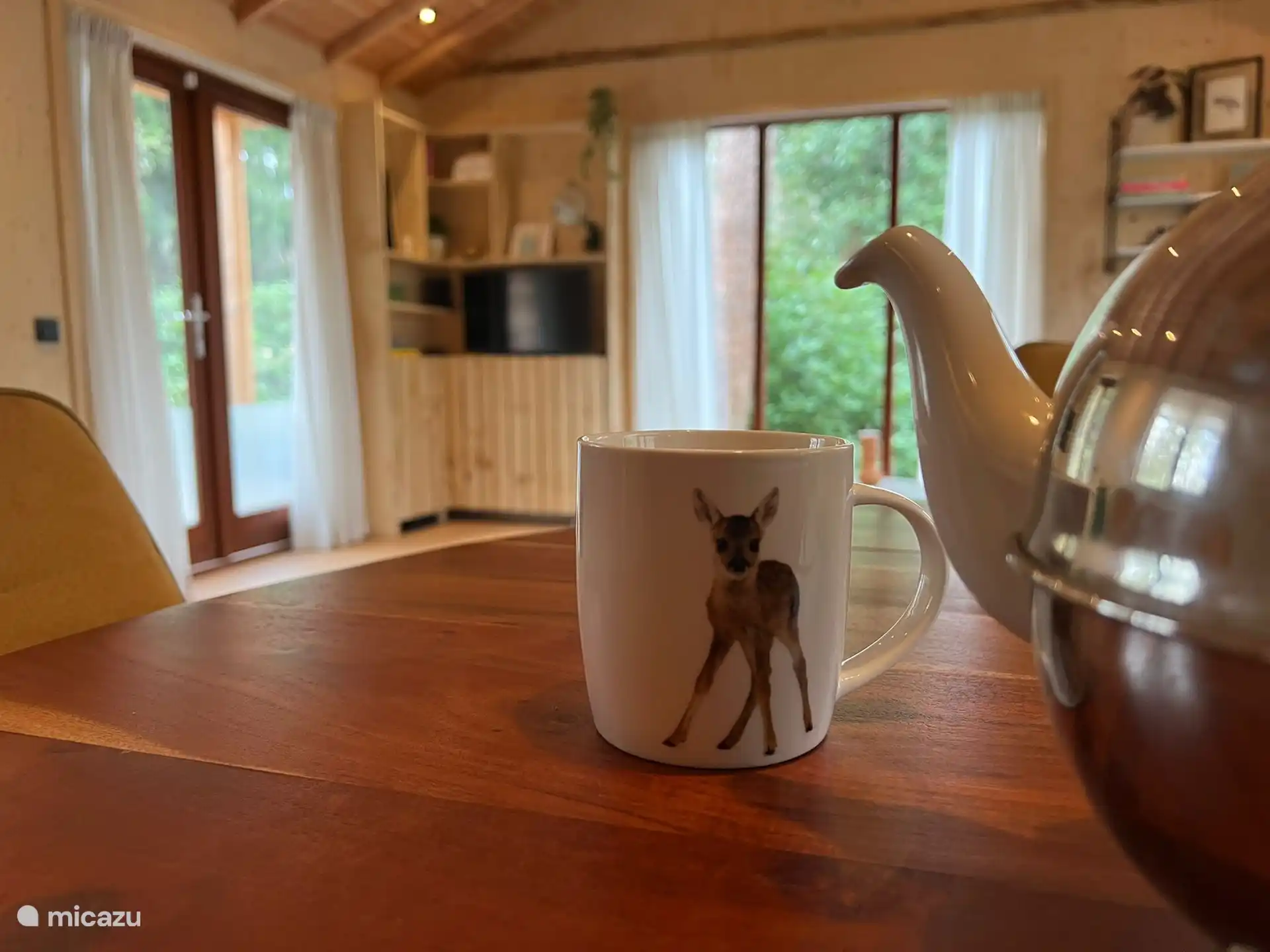 Atmosphäreneindruck vom Esstisch aus, mit Teekanne und „Design“-Becher