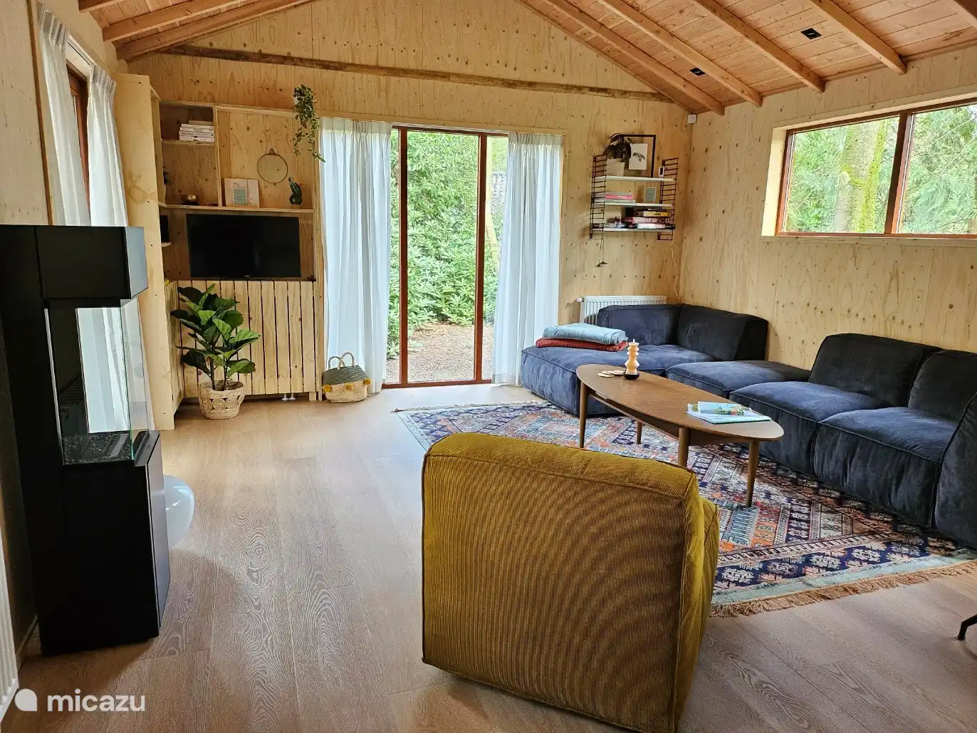 Wohnzimmer mit viel Tageslicht, einer schönen Sitzecke und einem Sessel