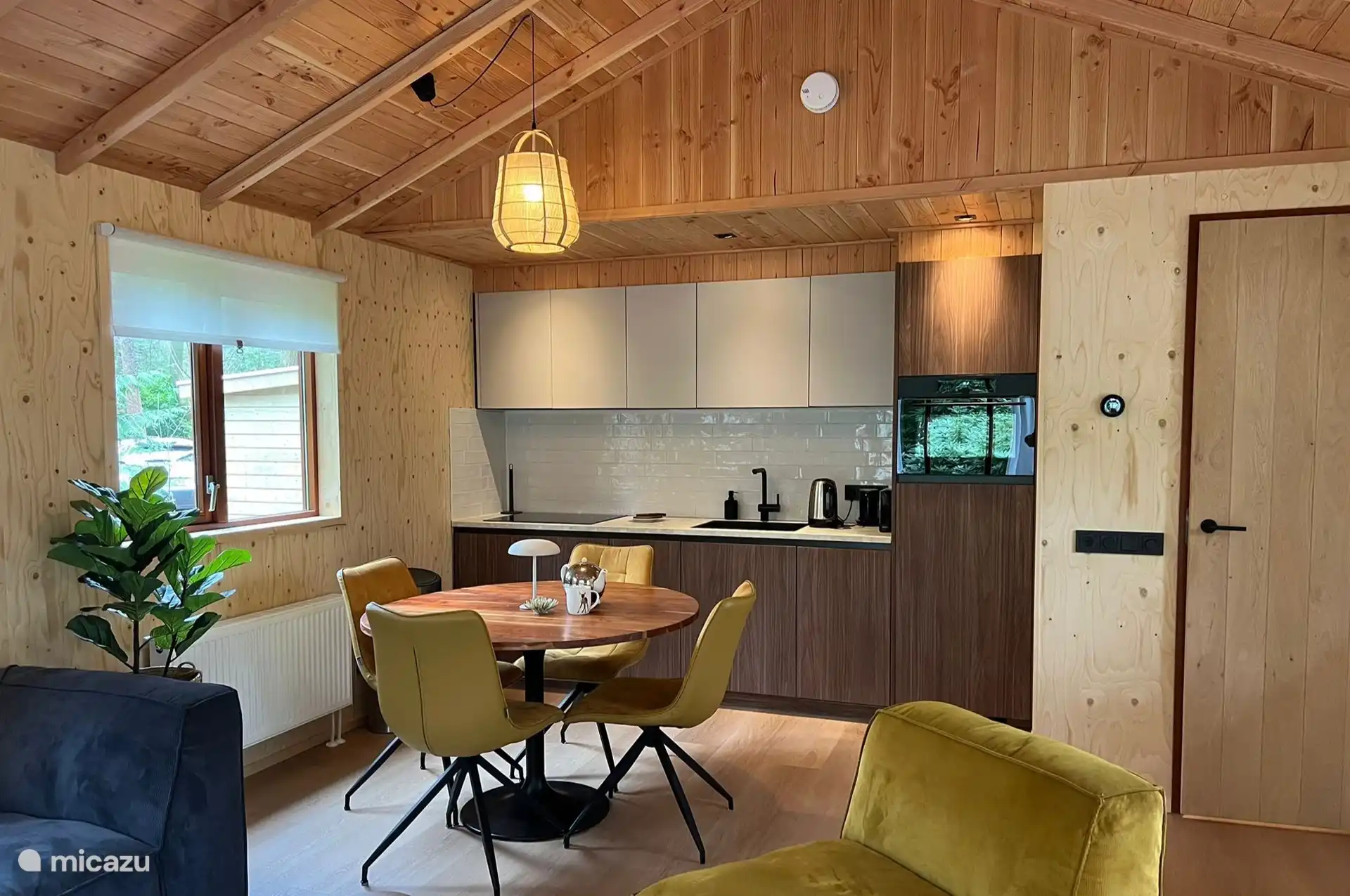 Moderne Küche mit Esstisch, Induktionskochfeld, Kühlschrank, Gefrierschrank, Mikrowelle