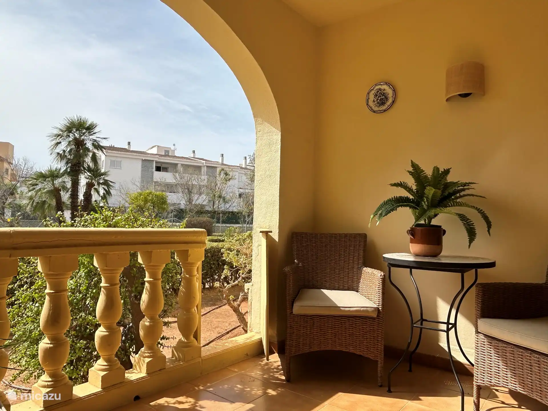 La terrasse avec table à manger et 2 chaises avec accès au jardin.
