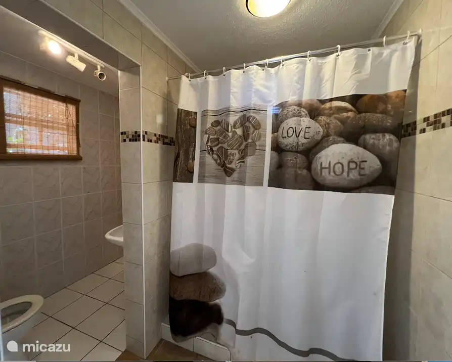 Cuarto de baño con ducha y WC. No hay agua caliente, pero el sol siempre presente calienta las tuberías que se encuentran sobre el suelo.