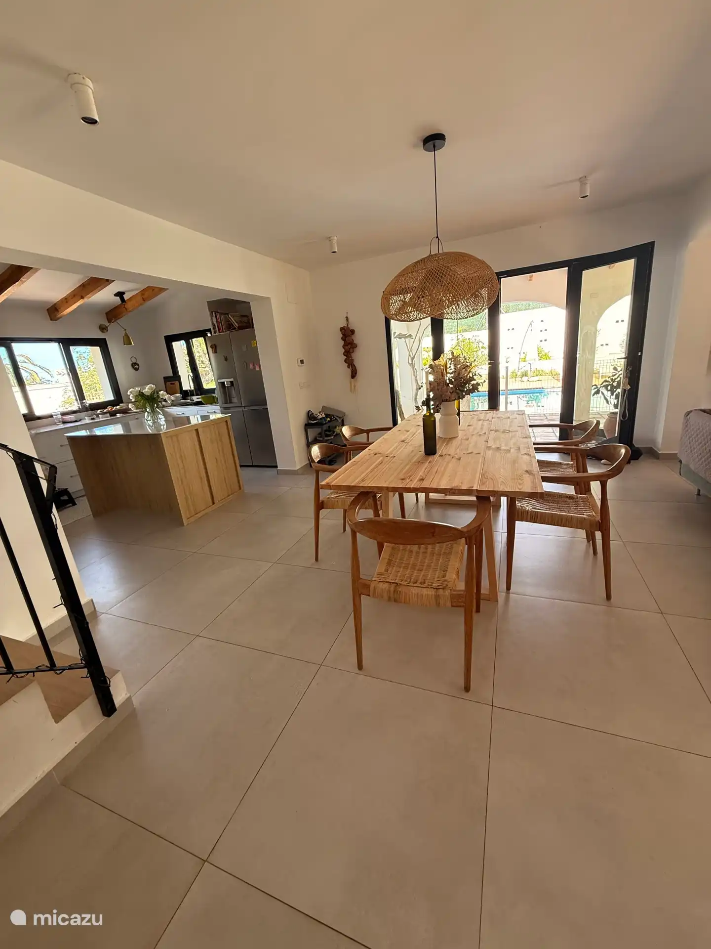 Essbereich und offene Küche mit Zugang zur überdachten Terrasse und zum Pool. 