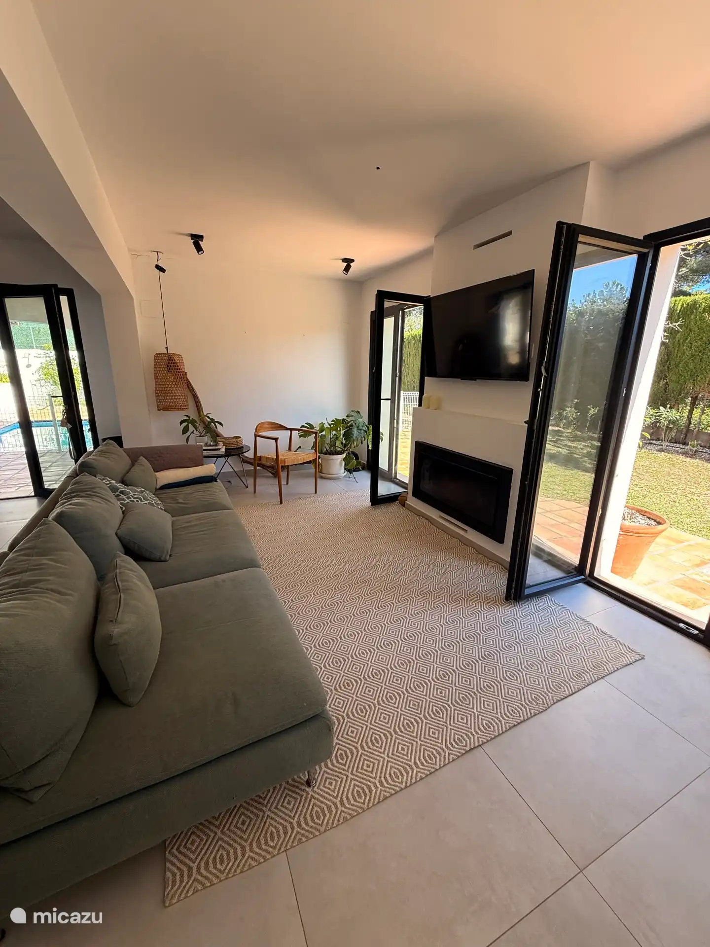 Wohnzimmer neben dem Essbereich, mit 4 Meter breitem Sofa, Klimaanlage, Smart-TV mit Netflix und Prime Video, Kamin und Zugang zum Garten. 