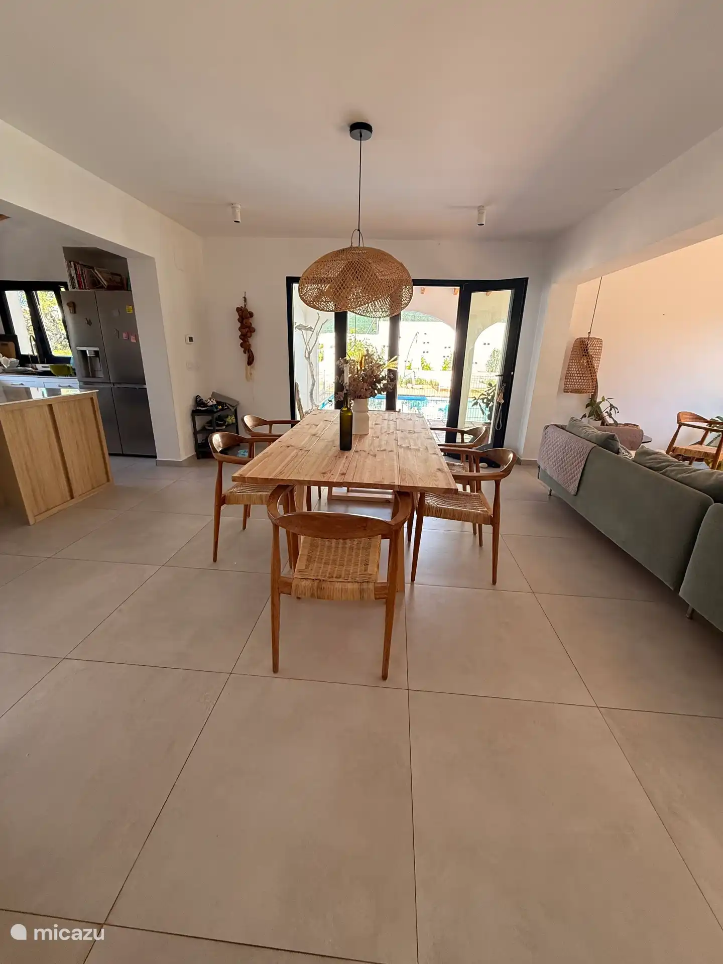 Essbereich und offene Küche mit Zugang zur überdachten Terrasse und zum Pool. 