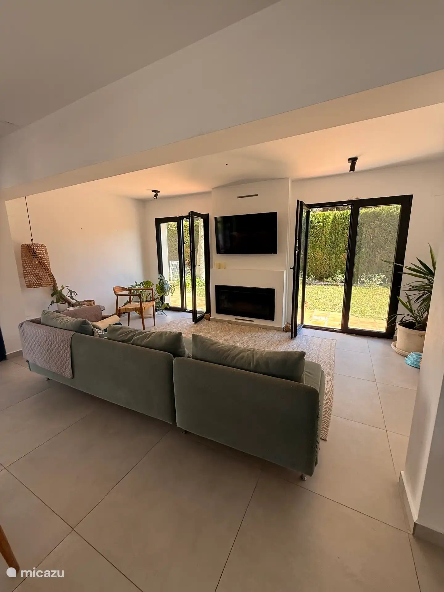 Wohnzimmer neben dem Essbereich, mit 4 Meter breitem Sofa, Klimaanlage, Smart-TV mit Netflix und Prime Video, Kamin und Zugang zum Garten. 