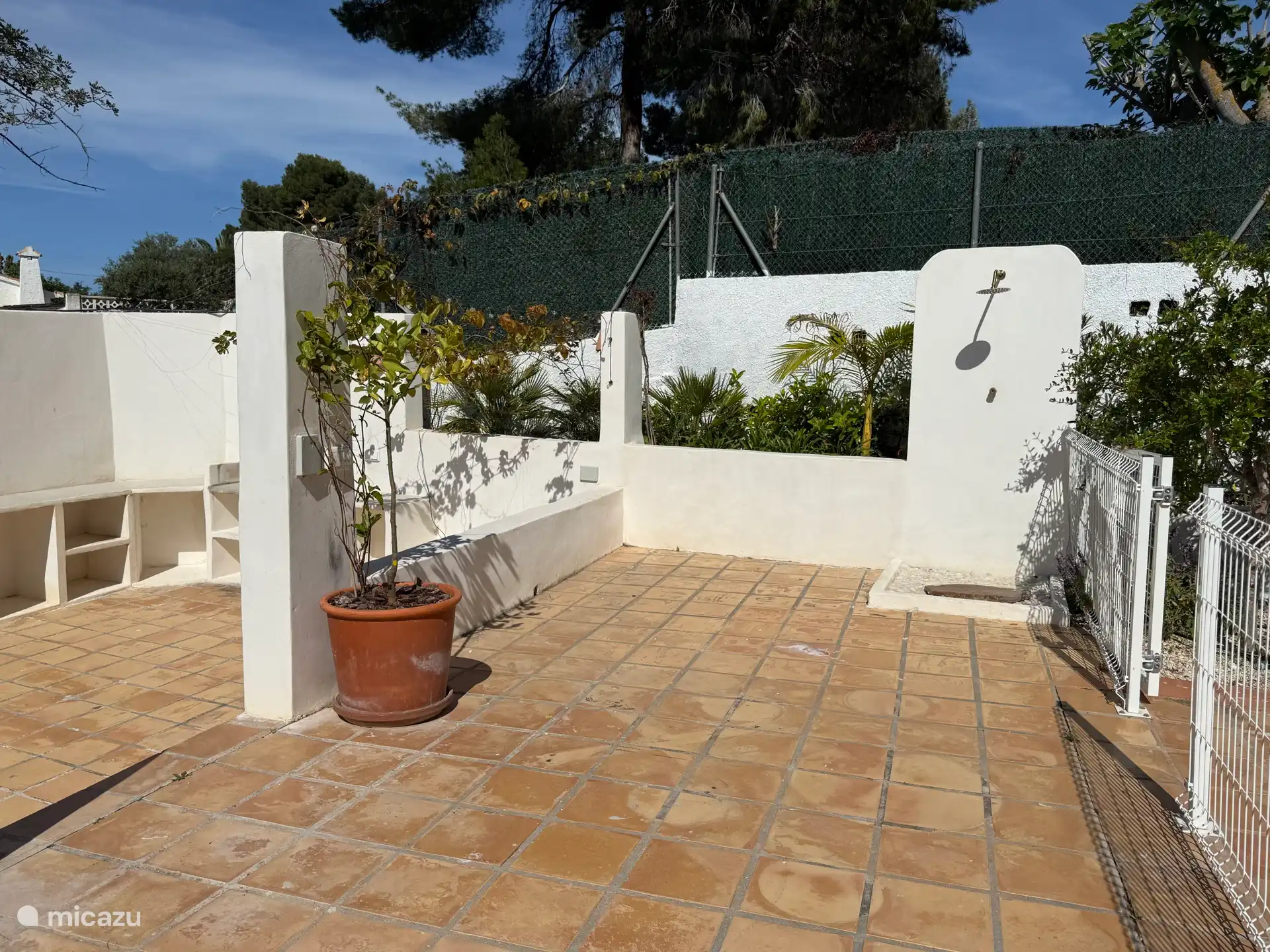 Außenterrasse mit Dusche, neben Grillplatz und Pool. 