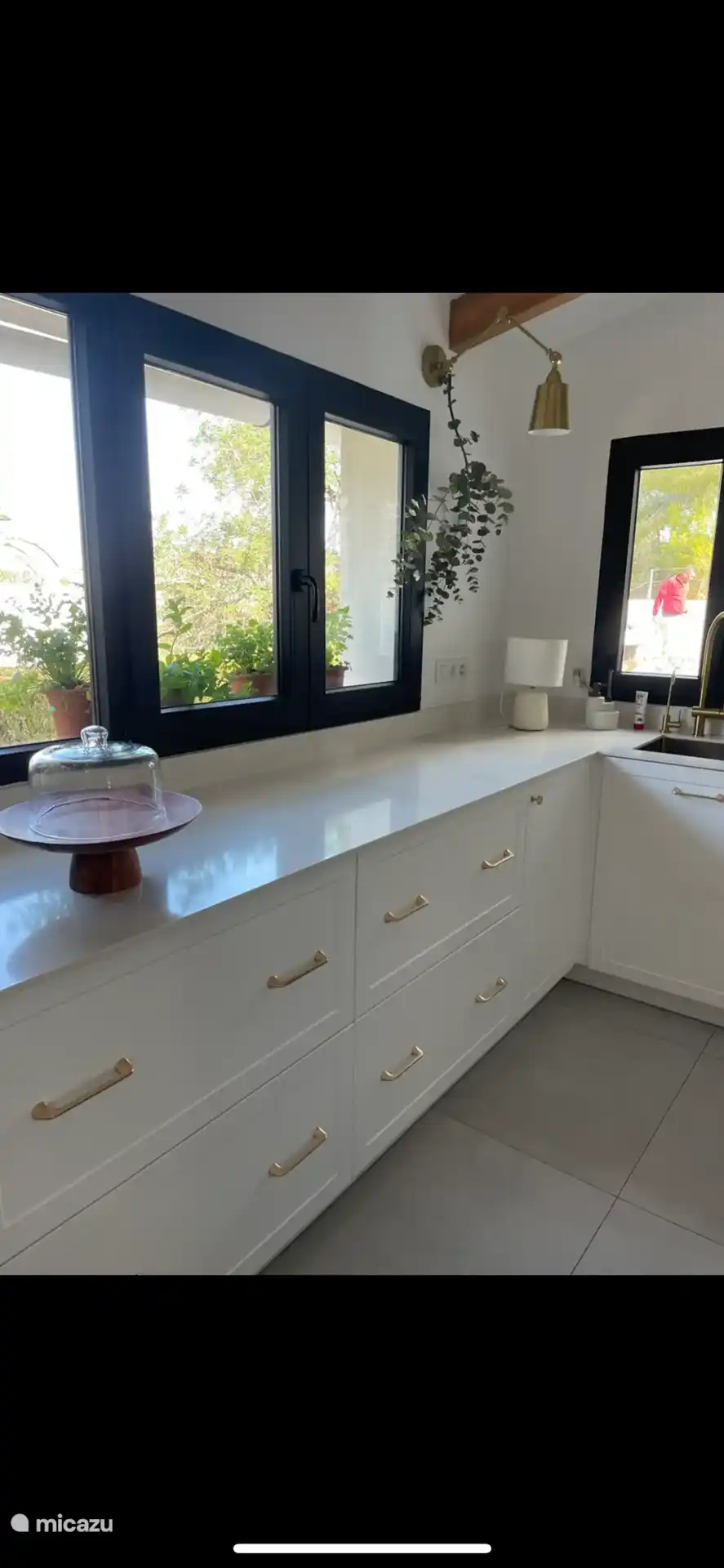 Neu renovierte Küche, komplett ausgestattet mit Side-by-Side-Kühlschrank, Eismaschine, Mikrowelle, Backofen und Kochfeld. Blick auf den Garten und den Pool. 