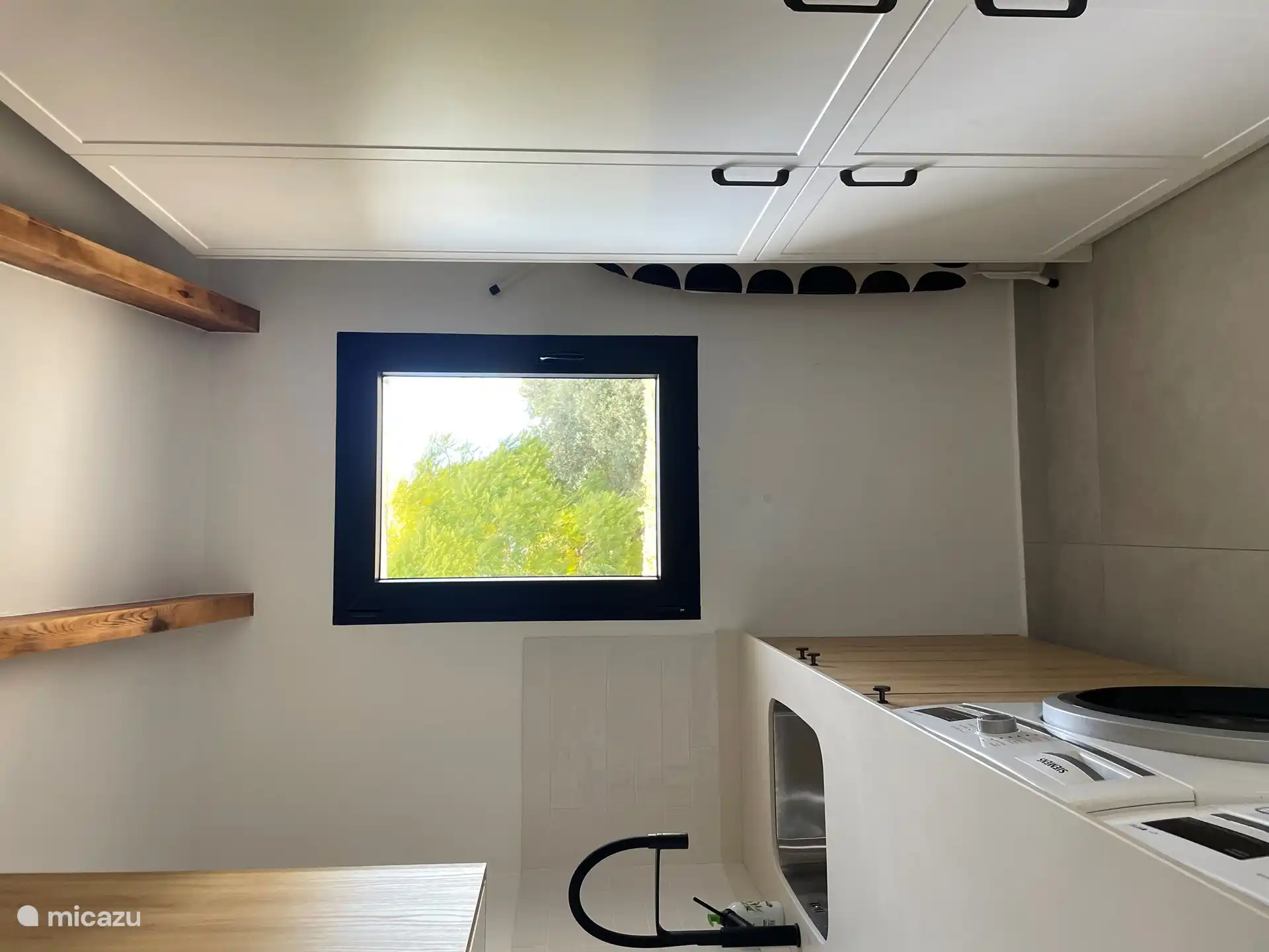 Waschküche neben der Küche mit Waschmaschine und Trockner. 