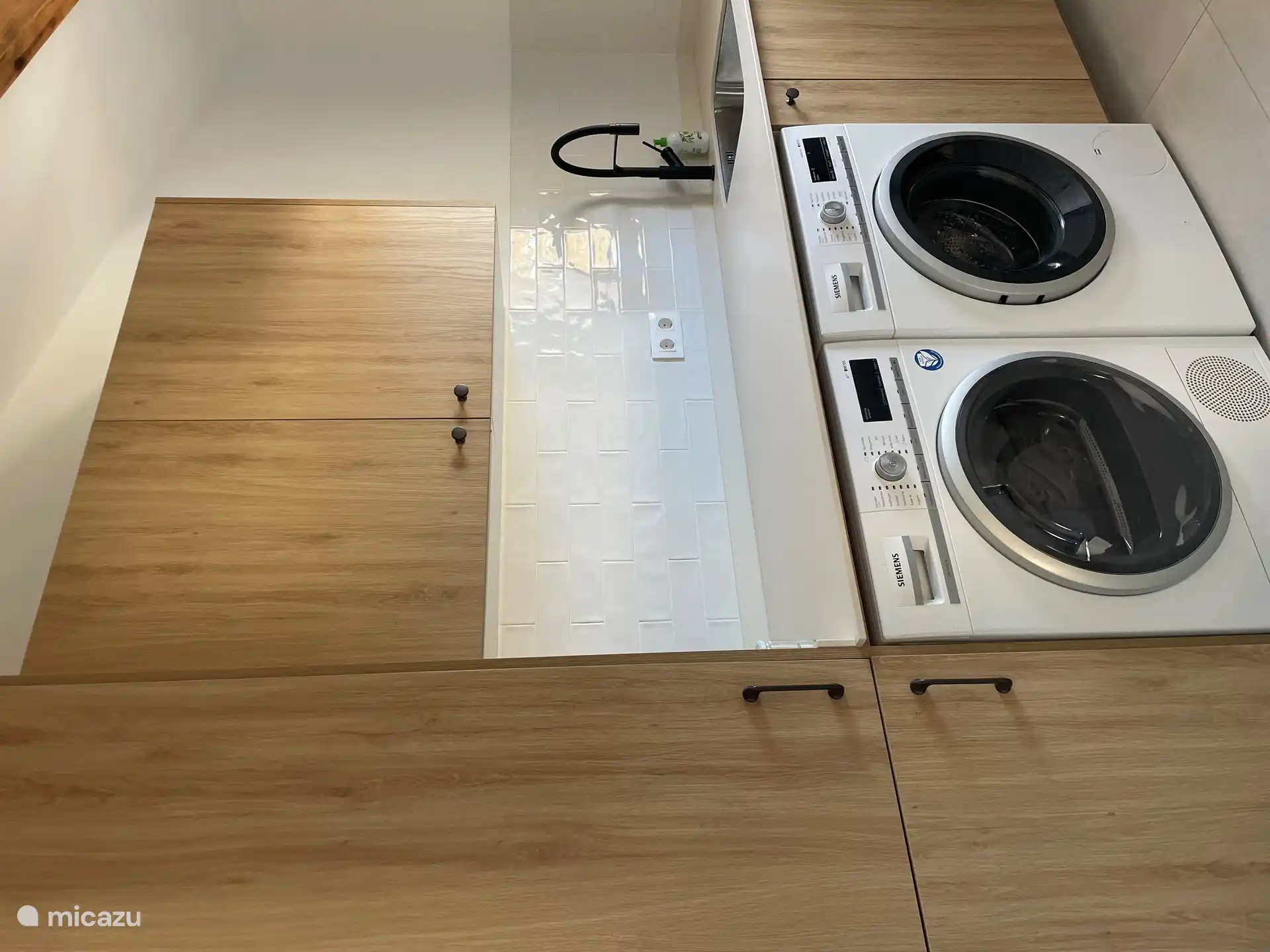 Waschküche neben der Küche mit Waschmaschine und Trockner.