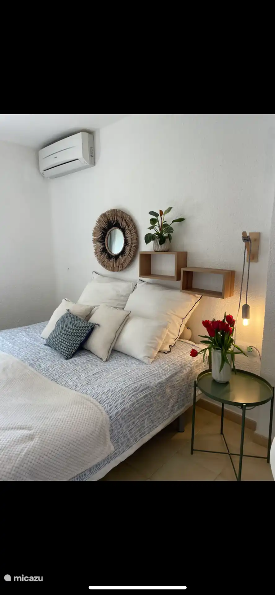 Zweites Schlafzimmer im Erdgeschoss mit einem Queensize-Bett, Klimaanlage und Blick auf den Garten. 