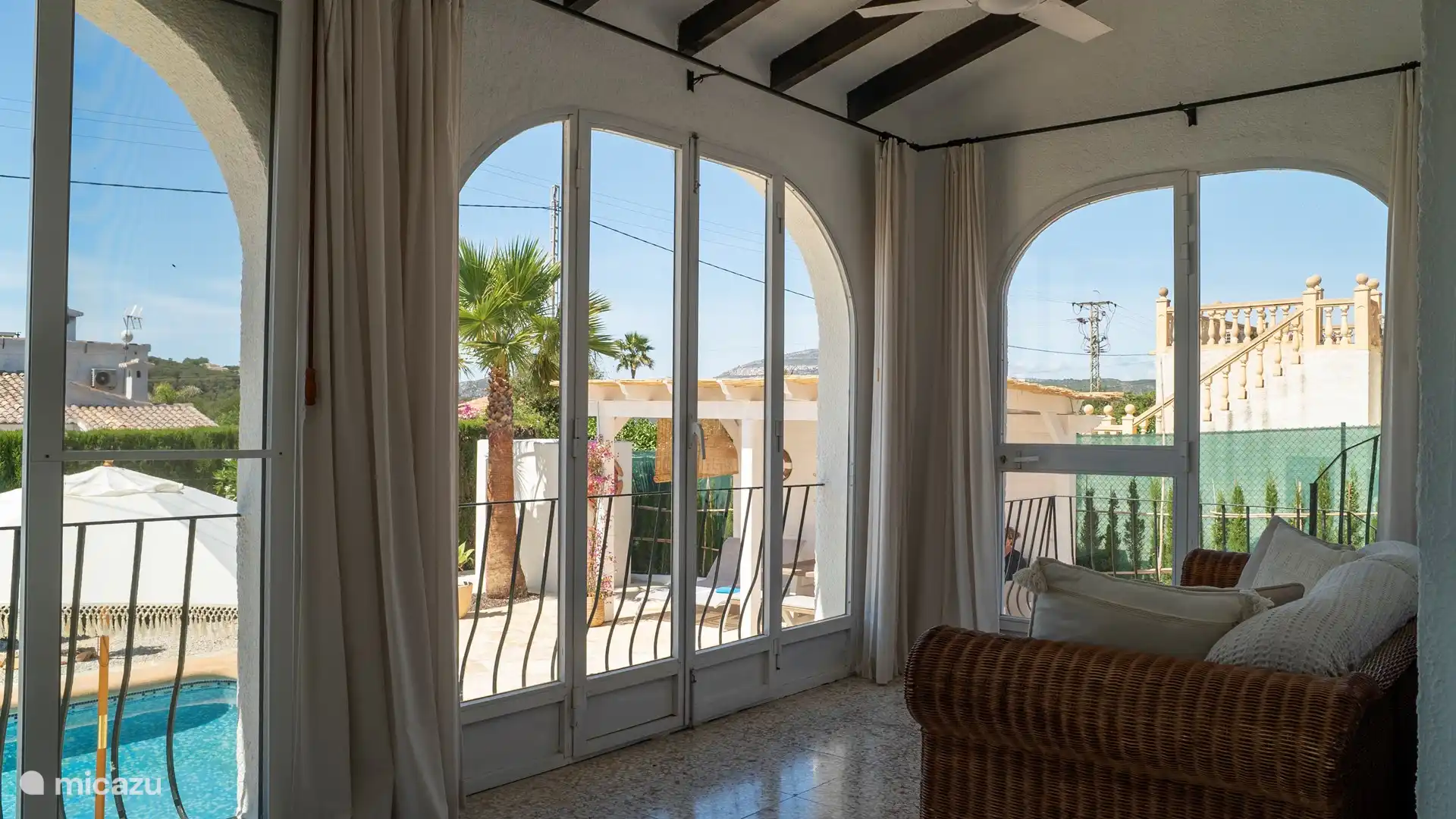 Überdachte Naya (Veranda) mit Sitzbank und Gartenblick.