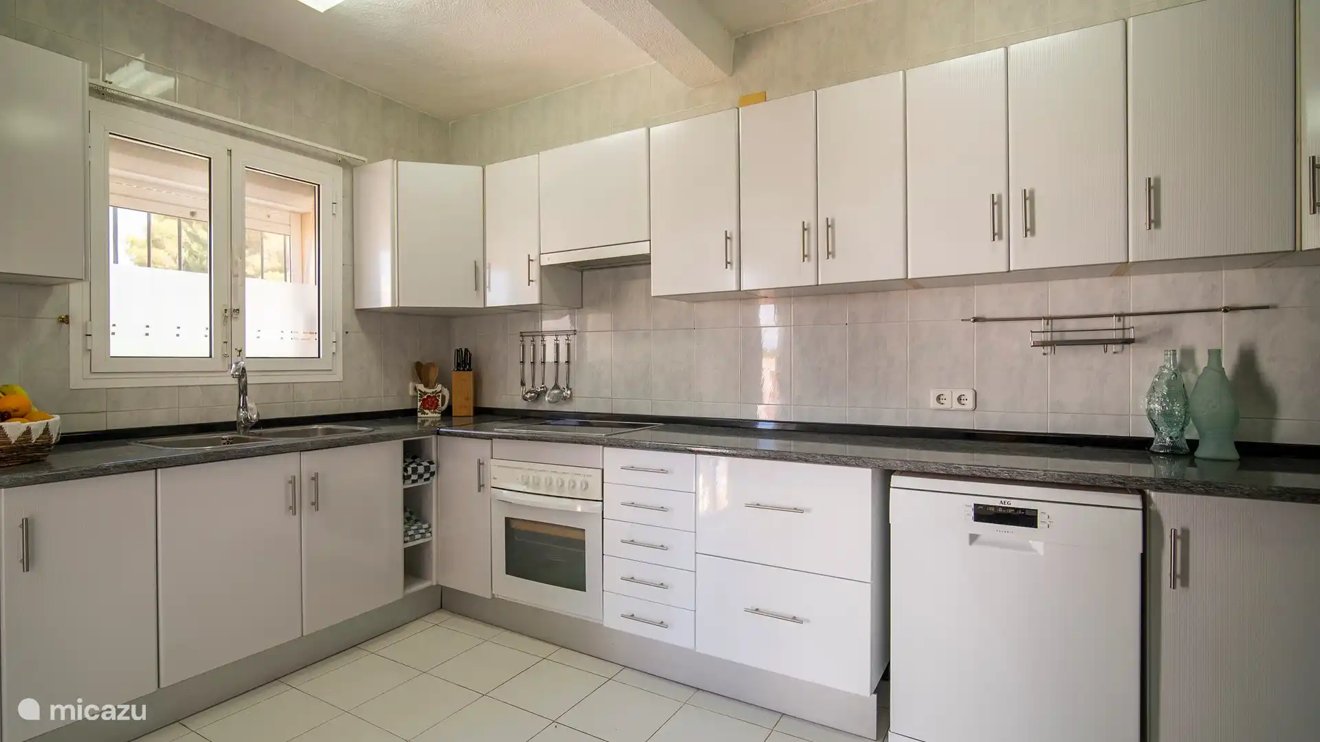 Geräumige Küche mit allen notwendigen Einrichtungen, einschließlich Geschirrspüler, großem Kühlschrank mit Gefrierfach, Backofen und Cerankochfeld.