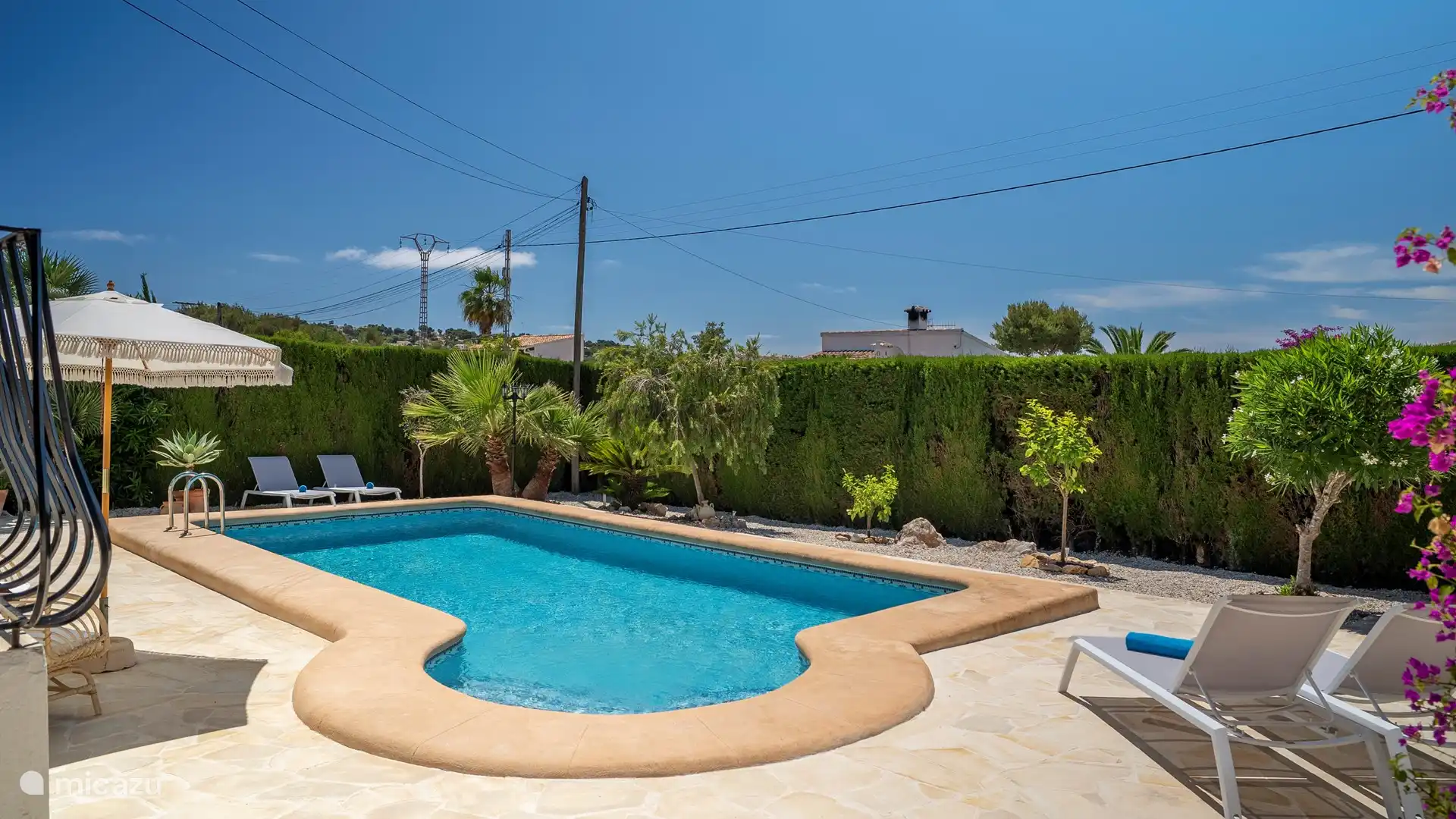 Salzwasser-Schwimmbad mit 4 Liegestühlen und Sonnenschirmen.